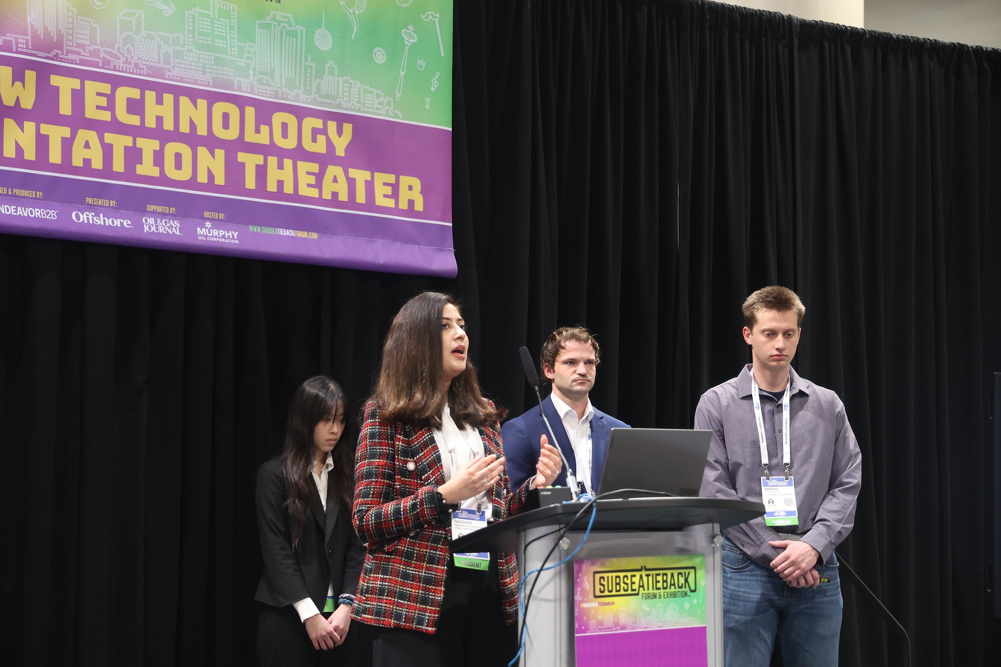 Student team presenting on stage at the New Technology Presentation Theater